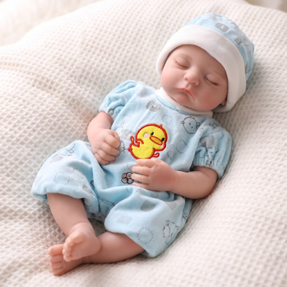 Noah doll in baby blue duck romper and striped hat