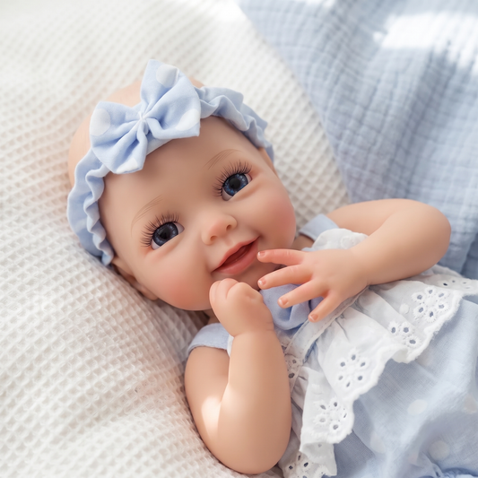 Terry silicone smiling baby doll in blue bow and white eyelet top